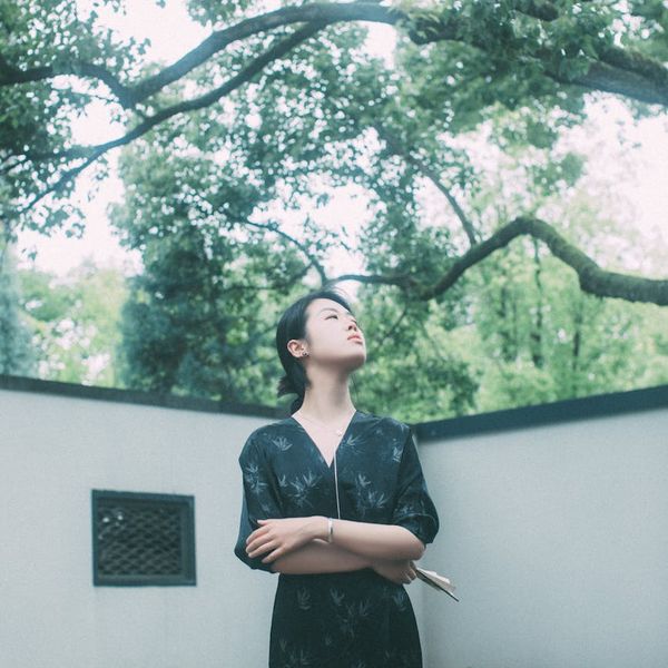 Calm person meditating in a peaceful, natural environment with soft light.
